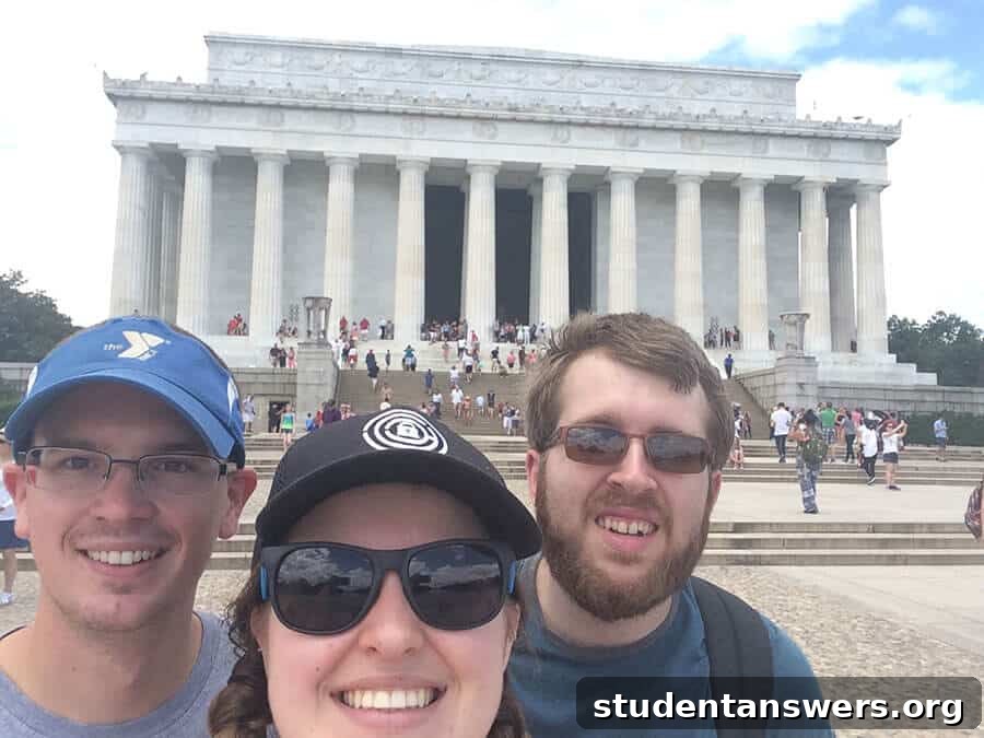 Three friends smiling and posing for a photo in a city.