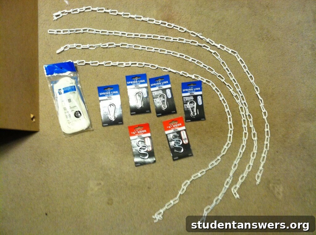 Coiled chains, rope, S-hooks, and spring links laid out on a wooden surface.