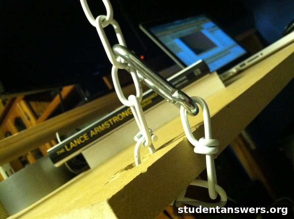 A chain looped through a hole in the desk and secured with a metal S-hook.