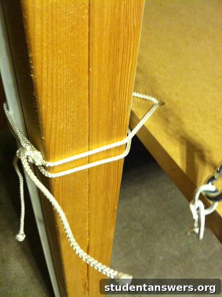 Rope is tied through a hole in the desk and around a loft bed post to stop swinging.