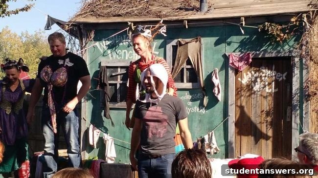 A man playfully wearing a bra on his head in front of a crowd at a festival