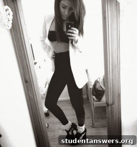 A woman styling a black ruched bandeau top with a white blazer.