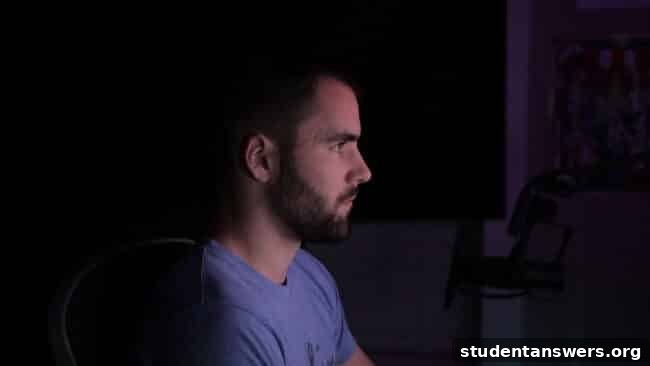 A person looking at a glowing smartphone screen in a dark room