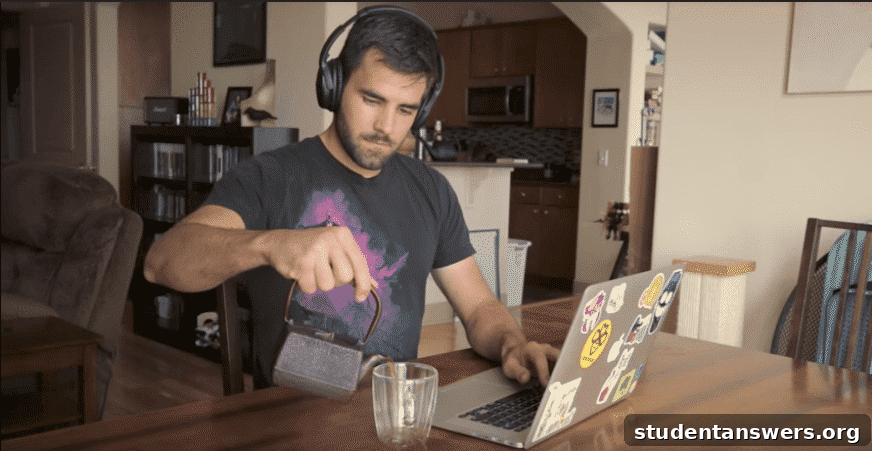 A person enjoying a cup of tea while working on a laptop, showing a pleasant study ritual.