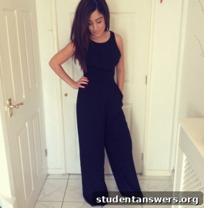 A woman wearing a sophisticated black open-back jumpsuit, showing its flattering fit.