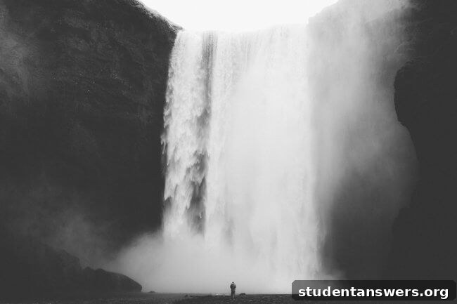 A black and white photo of a powerful waterfall