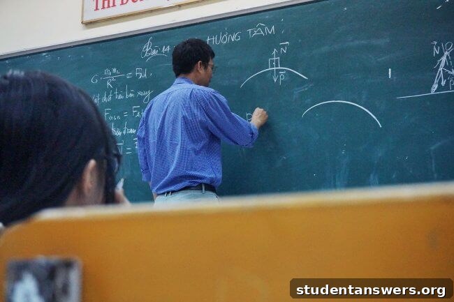 A professor writing complex physics equations on a whiteboard