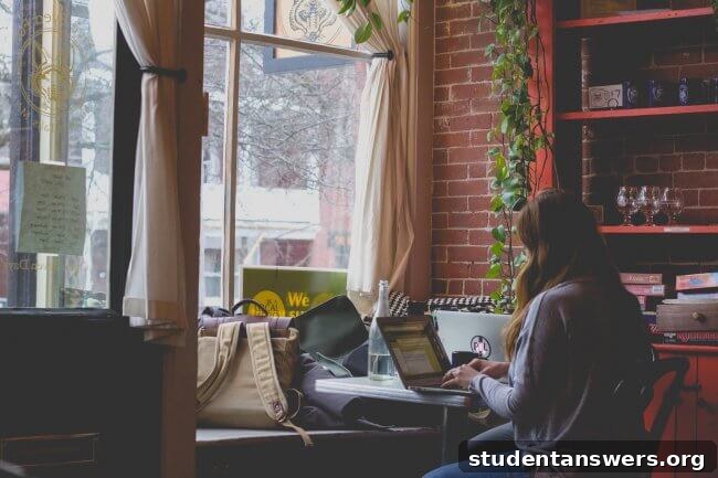 A student working on a laptop in a cozy coffee shop