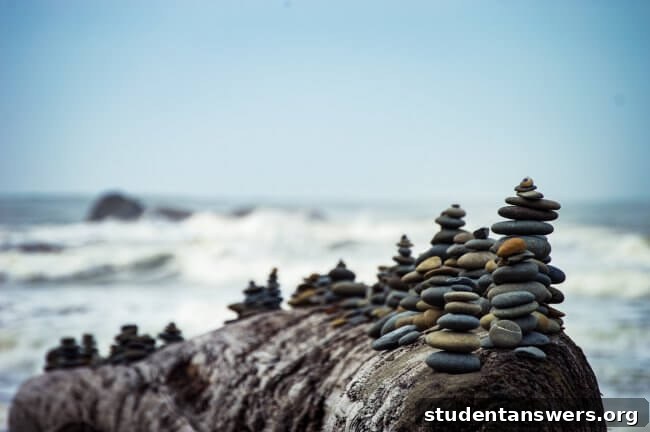 Piles of pebbles balanced perfectly on a beach in front of the ocean