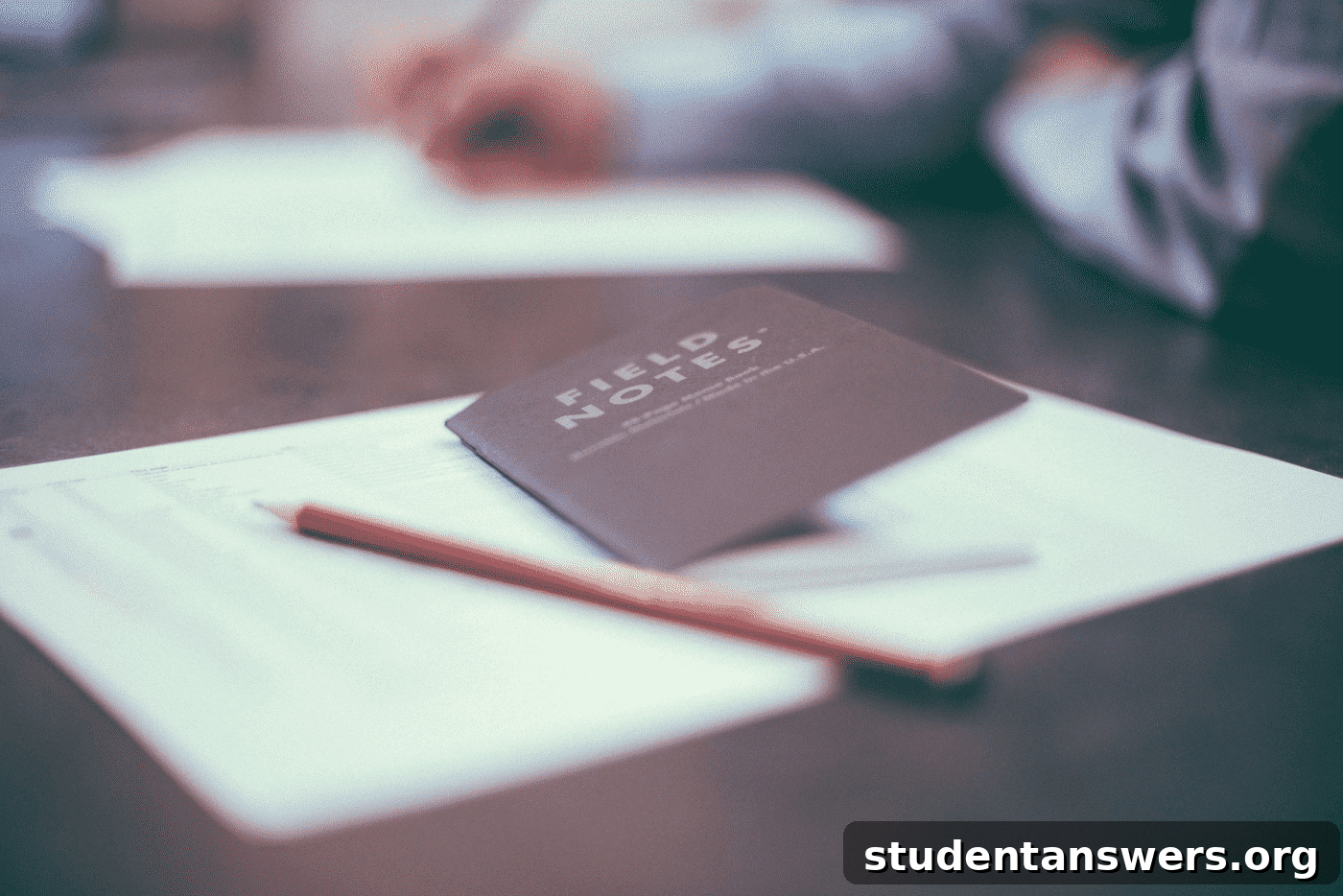 A notebook and pen on a wooden desk, symbolizing interview preparation