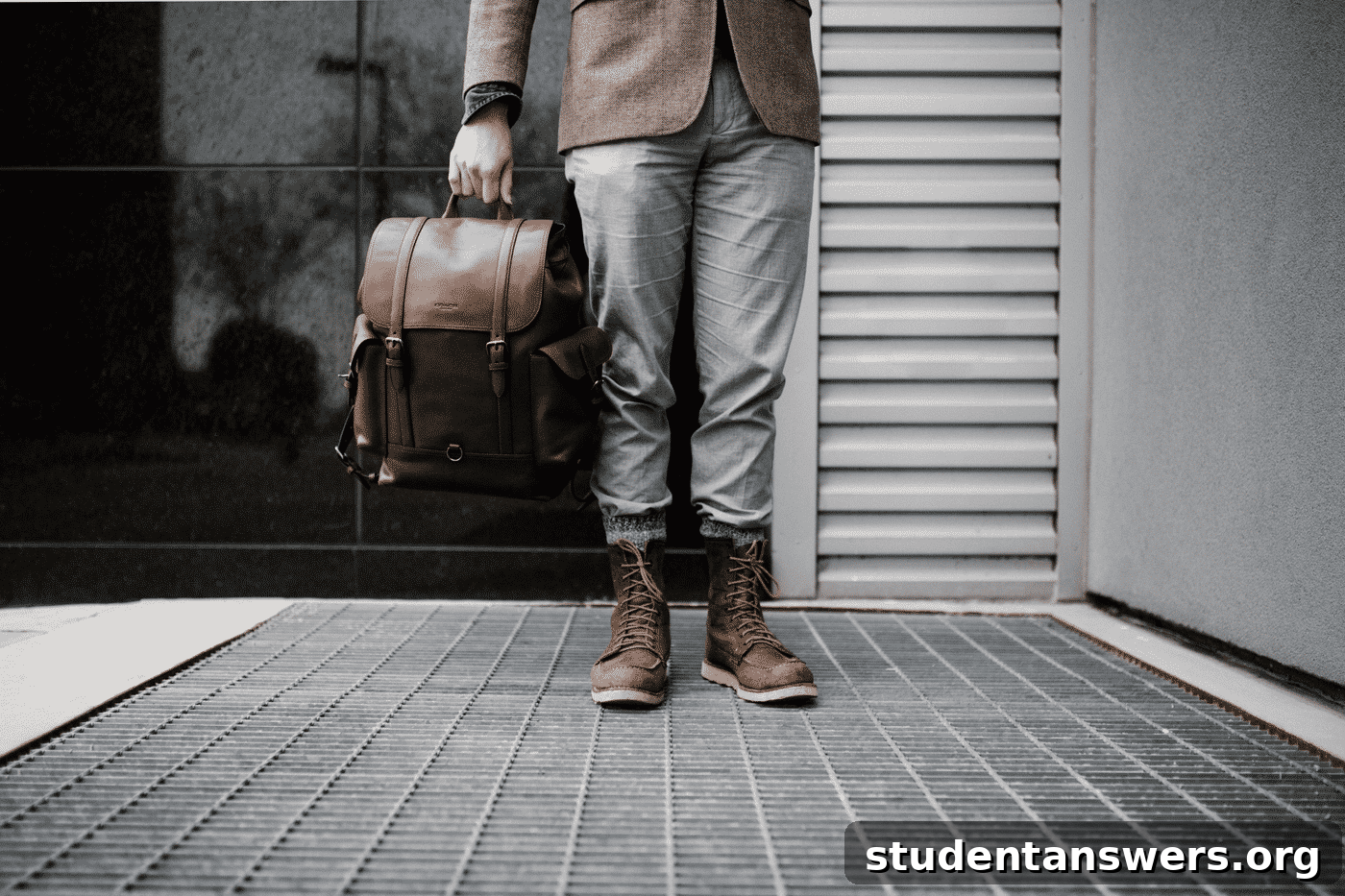 A person dressed professionally holding a leather briefcase.