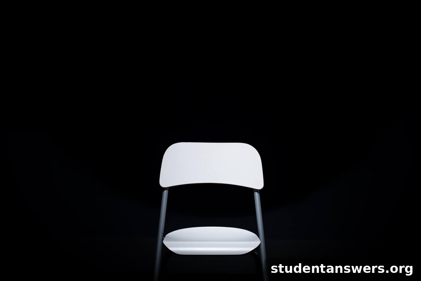 A single chair in a spotlight in a dark room, representing the interview hot seat.