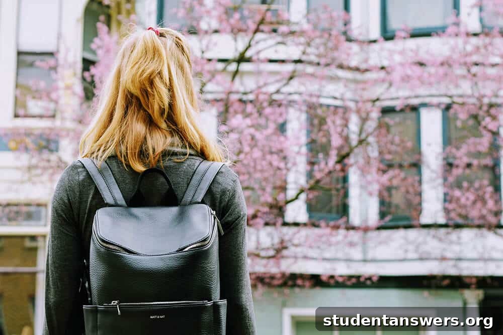 A female student with a backpack smiles, ready to take advantage of her student status.