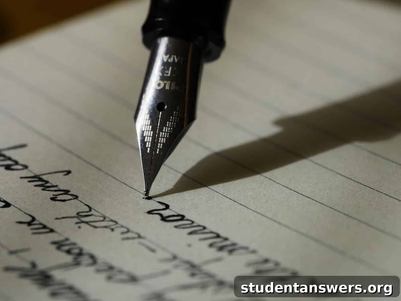 A hand holding a fountain pen, poised to write on paper, symbolizing the planning stage of essay writing.