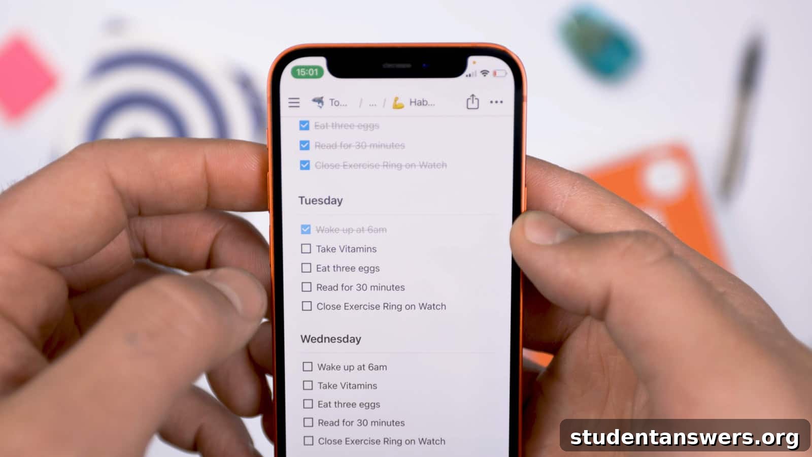 A person holding a smartphone displaying a habit tracker template built within the Notion app.
