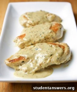 A delicious plate of chicken in a creamy white wine sauce, garnished with fresh herbs