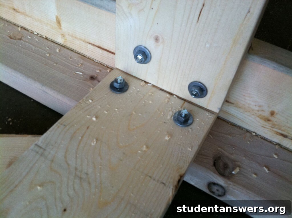 The top frame board being bolted to an L-shaped post.