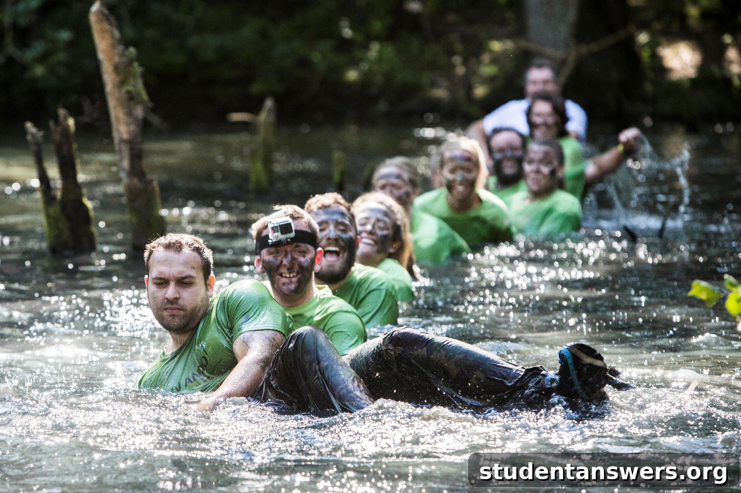 A participant in the Commando Series obstacle course race, covered in mud and tackling an obstacle.