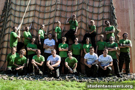 A group of smiling, mud-covered participants at the Commando Series finish line.