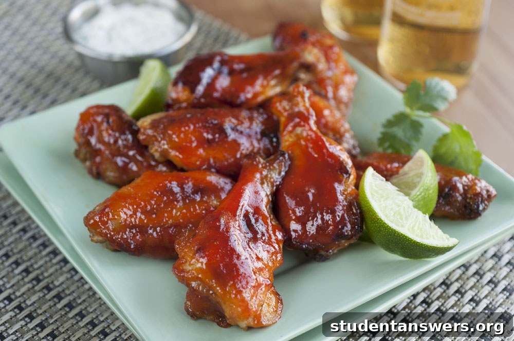 A plate of glossy, spicy Buffalo chicken wings ready to be served with a side of dipping sauce.
