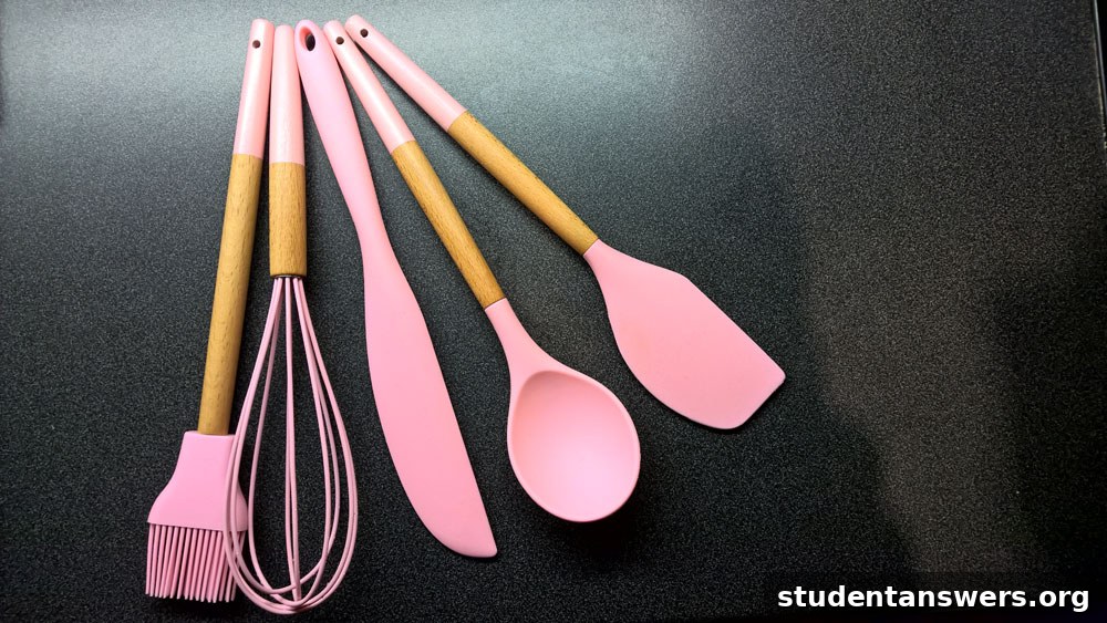 A collection of pink silicone baking utensils from the Aldi range laid out on a surface.