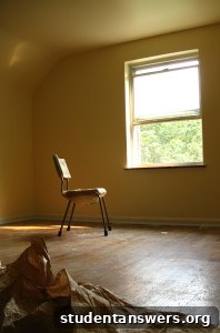 A well-decorated university dorm room with fairy lights and photos on the wall.