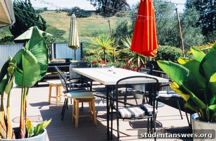 A comfortable and inviting outdoor seating area made from budget-friendly furniture and cushions.