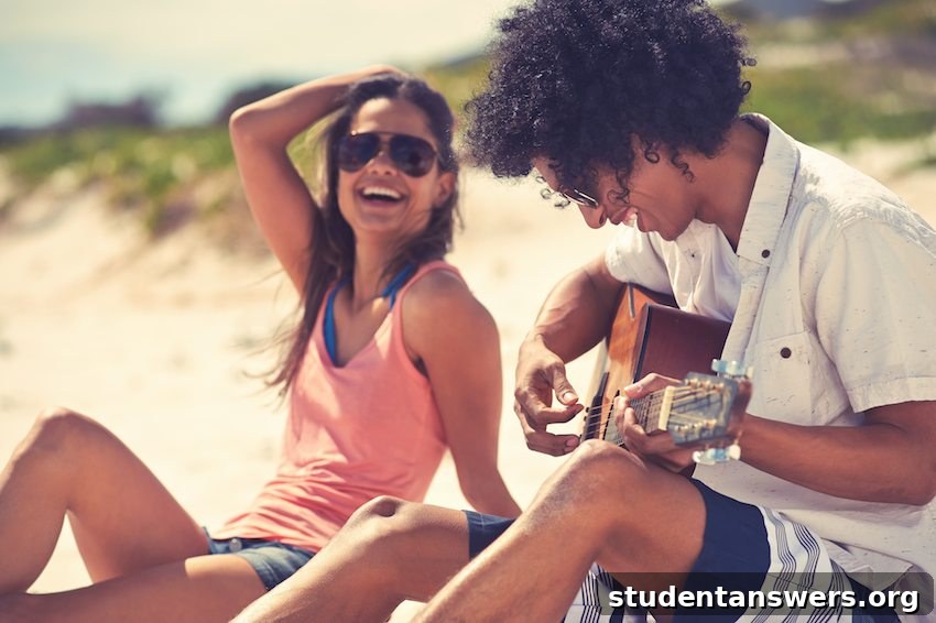A couple playing guitar on the beach at sunset