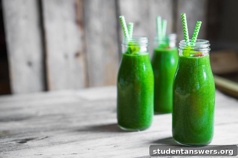 A healthy green smoothie in a glass with a straw