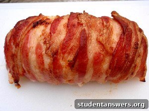 A perfectly cooked bacon-wrapped stuffed chicken breast, sliced to reveal a melted cheese and herb filling.